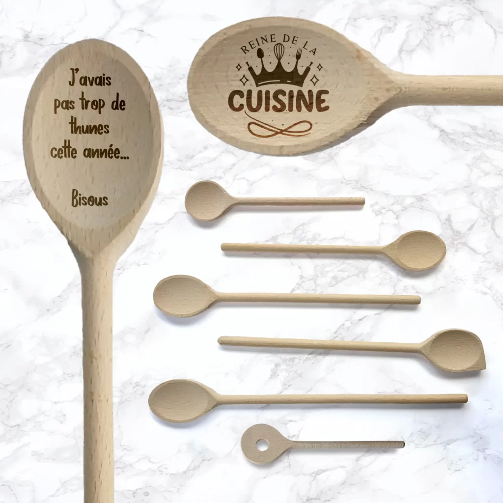 Cuillères en bois personnalisées gravées avec un texte "Désolé j'avais pas de thunes cette année" et un logo "Reine de la cuisine"